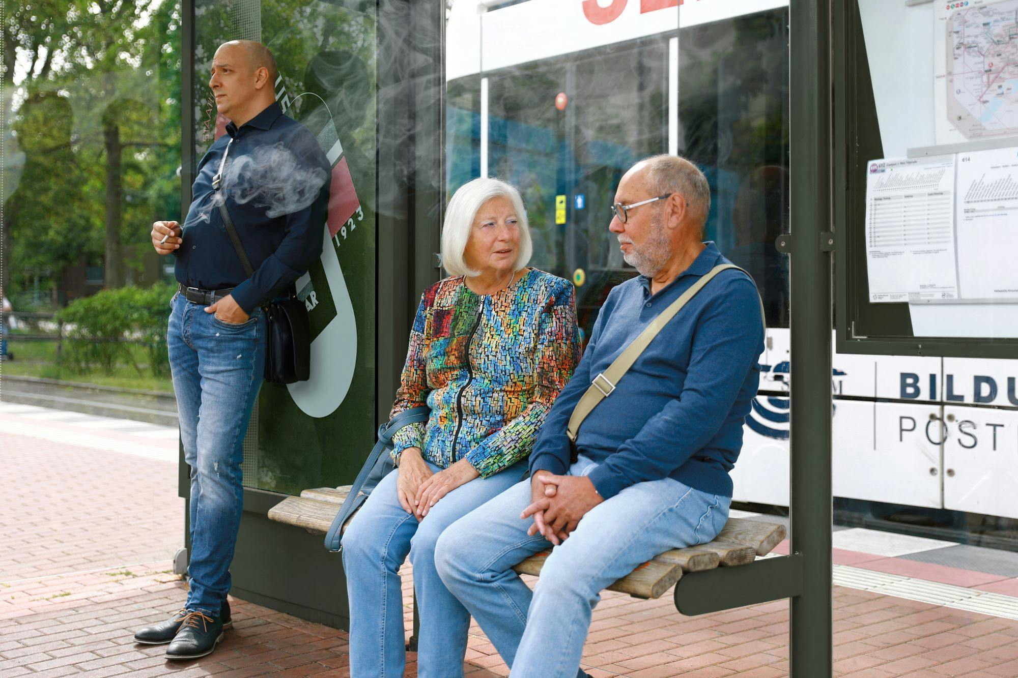Stock image of people waiting at a bus stop
