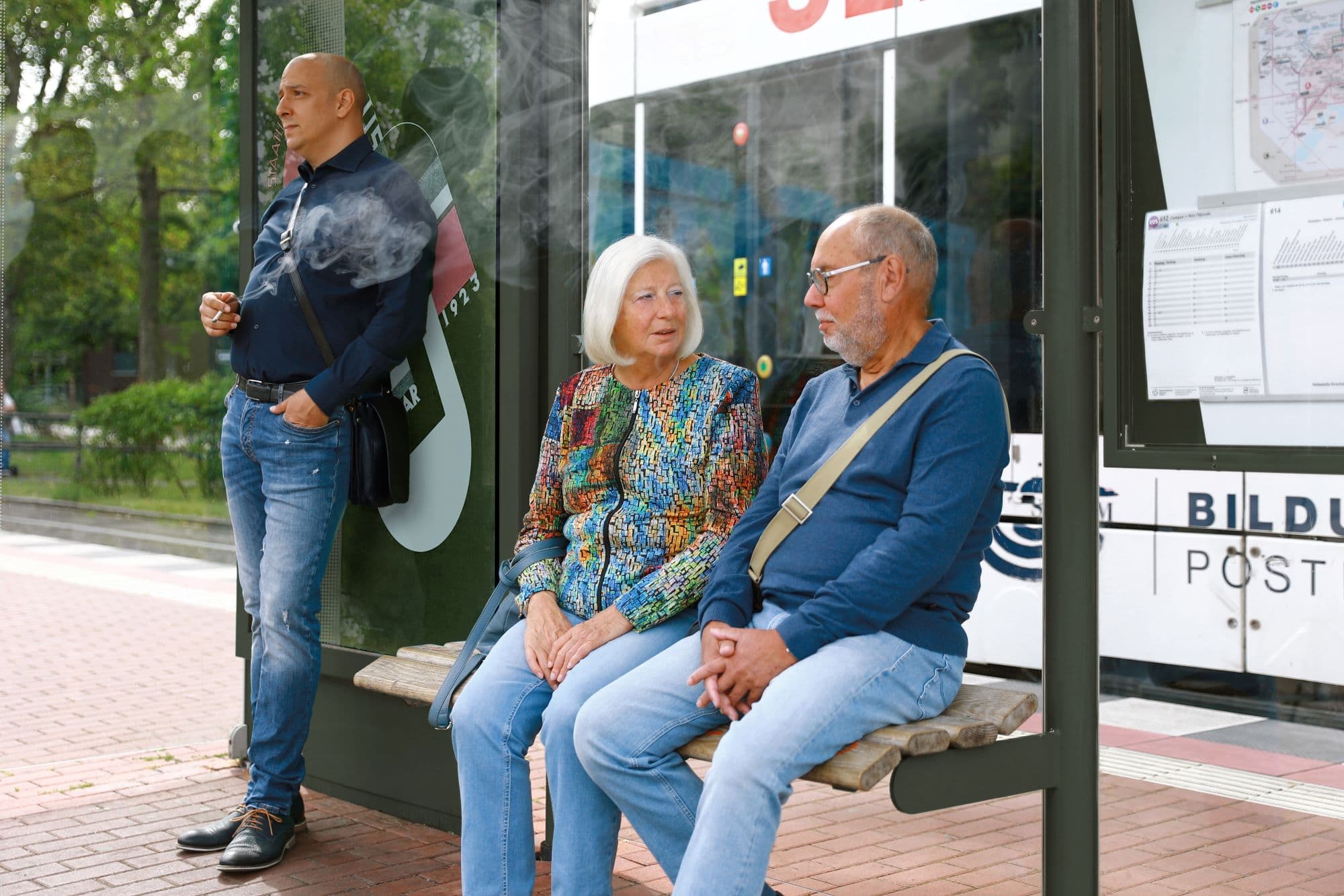 Stock image of people waiting at a bus stop