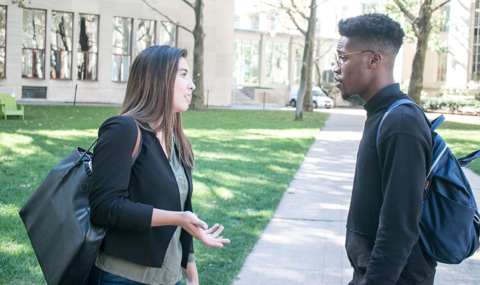 Stock image of two people talking on a sidewalk